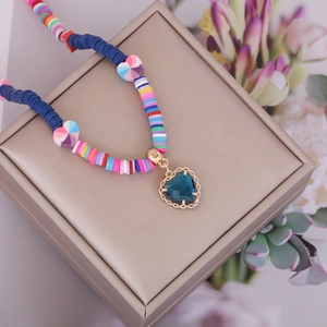 Close-up of bohemian beaded necklace featuring a blue heart pendant on a jewelry box