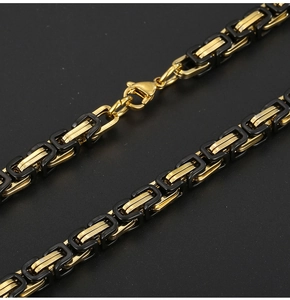 Vue macro de la chaîne byzantine de 6mm bicolore avec maillons dorés et revêtement noir