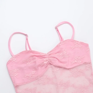 Close-up of pink lace dress detailing featuring delicate crochet and adjustable straps
