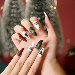 Christmas press on nails with long coffin shape featuring green reindeer and snowflake designs