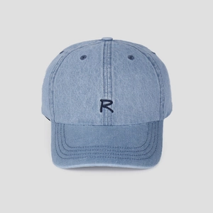 Detailed close-up of dark blue R letter embroidery on light blue washed denim baseball cap