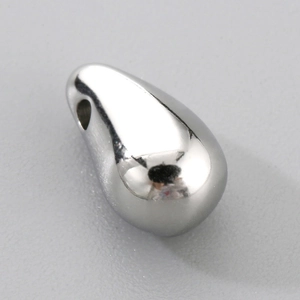 Macro shot of silver teardrop pendant in polished stainless steel with top hole detail