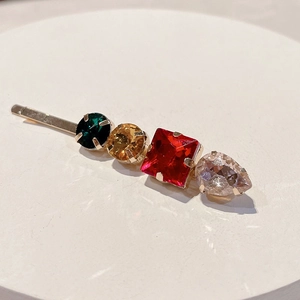 Detailed macro view of colorful rhinestones on a golden metal minimalist hair clip