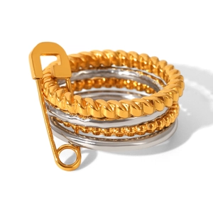Close-up of mixed metal layered rings with gold twisted band and silver band joined by pin