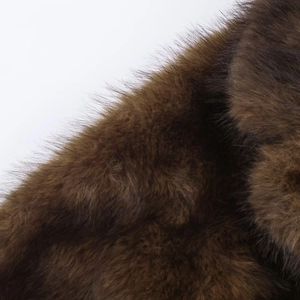 Vue détaillée en gros plan de la texture de fourrure synthétique marron foncé et des fibres