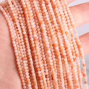 Macro detail of natural pink-orange round mineral stone beads with unique textures