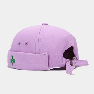 Detail of light purple miki hat featuring green clover embroidery and adjustable metal buckle