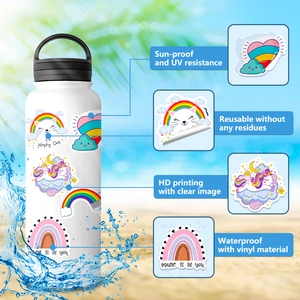 Waterproof rainbow and unicorn vinyl stickers displayed on a white bottle in a beach setting