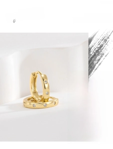 Gros plan de boucles d'oreilles créoles S925 en argent et zircon sur socle blanc