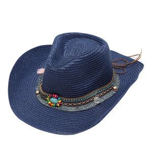 Detail of blue straw cowboy hat featuring turquoise beads and metallic coin charms