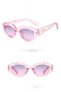 Detail view of pink cat-eye sunglasses with gradient lenses and golden metal accents