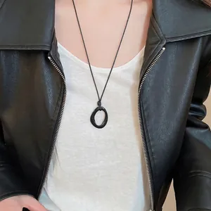 Collier à pendentif anneau géométrique noir minimaliste porté par un mannequin
