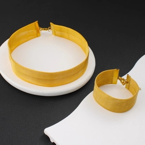 Détail du parure de bijoux en maille dorée avec collier ras du cou et bracelet assorti
