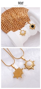 Detail view of golden sunburst pendant with white opal inlay on a sleek snake chain