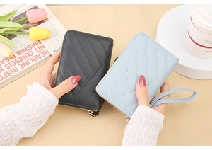 Women's quilted short zip wallets in black and light blue with wrist straps and gold hardware