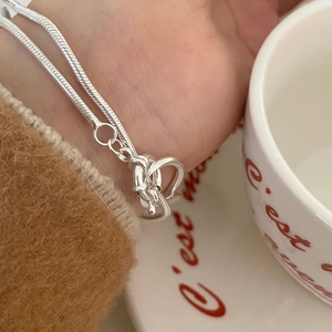 Detail of S925 sterling silver snake chain bracelet with unique knot buckle design