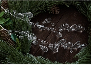 Detailansicht der klaren Acryl-Perlengirlande am Kiefernzweig für die Weihnachtsdeko