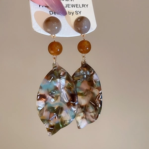 Detailed view of vintage acetate leaf earrings with amber tones and silver needles
