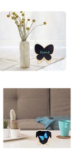Detail of butterfly shaped chalkboard with wooden base used for home and cafe decor