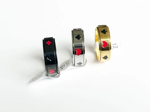 Close-up of rotatable card suits rings in black, gold, and silver stainless steel