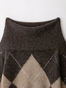 Gros plan du pull en maille à losanges montrant la texture pelucheuse et le tissu épais