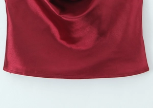 Détail du tissu satiné bordeaux montrant la texture brillante et le drapé naturel du haut