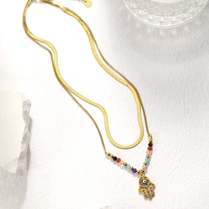 Detail of double-layer gold necklace showing Hamsa Hand pendant and S925 hallmark