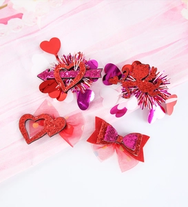Close-up of heart and bow hair clips with glitter fabric and romantic red mesh