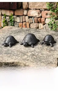 Detailed view of three vintage cast iron turtle figurines with a rustic brown finish