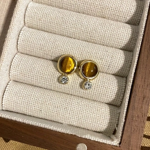 Retro geometric gold earrings with tiger eye stone and small zircon in a jewelry box