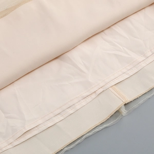 Detail of double-stitched hem and tulle seam on beige formal dress lining