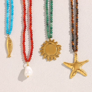 Detailed view of four beaded necklaces featuring sun, starfish, fish and pearl charms