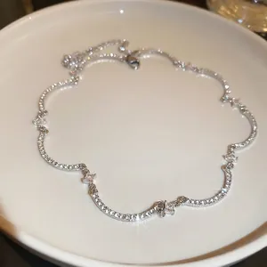 Collana choker curva con zirconi argentati e cristalli lucidi su vassoio di ceramica