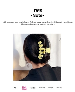 Détail d'une grande pince à cheveux jaune citron mat avec un design torsadé épuré