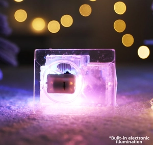 Détail d'un ornement lumineux transparent avec LED violette et base texture neige