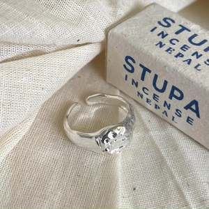 Close-up of a minimalist 925 sterling silver irregular texture open ring on linen