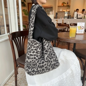 Detailed texture of leopard print faux fur shoulder bag in a stylish cafe setting