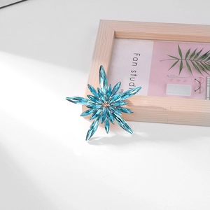 Detailed view of light blue snowflake brooch featuring faceted marquise crystals