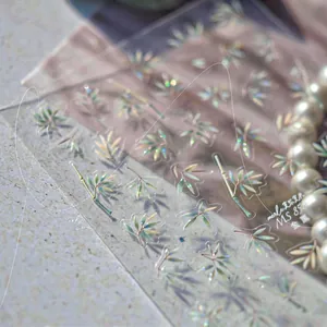 Macro shot of holographic gold bamboo nail art stickers with metallic finish details
