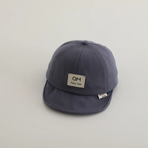Detailed close-up of dark grey cotton soft-brim baby cap with premium fabric texture