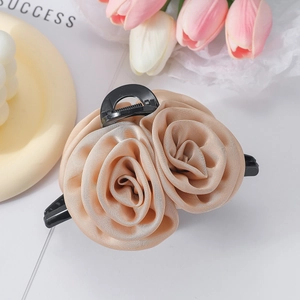 Detail shot of the champagne fabric rose hair claw clip with elegant satin texture finish