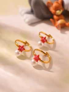 Detalle de pendientes de estrella de mar dorados con perlas sobre tela suave