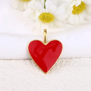 Detail of red enamel heart pendant with 18k gold plated trim and white daisy background