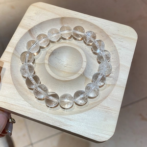 Detailed macro view of clear white crystal beaded bracelet with natural texture on wood