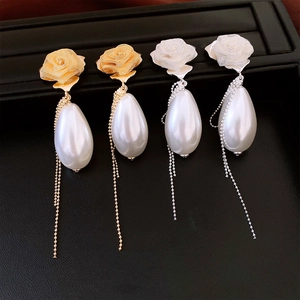 Detail of rose pearl tassel earrings featuring metal mesh flowers and dangling water drop pearls