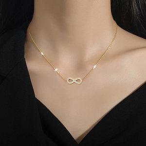 Titanium steel gold necklace with infinity symbol pendant and sparkling zircons on a model