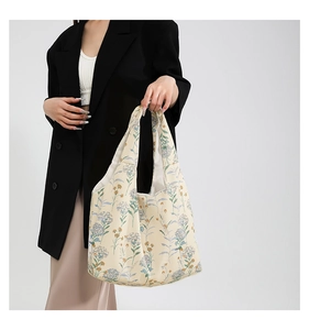 Detail of canvas tote bag featuring blue floral patterns and sturdy shoulder straps