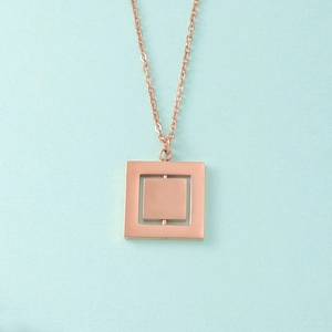Detail of rose gold rotatable geometric square pendant on a delicate link chain necklace