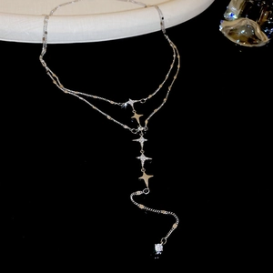 Macro shot of silver double-layered star necklace with sparkling rhinestones and tassel