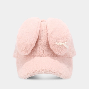 Gros plan sur la casquette en peluche rose avec oreilles de lapin et nœud blanc